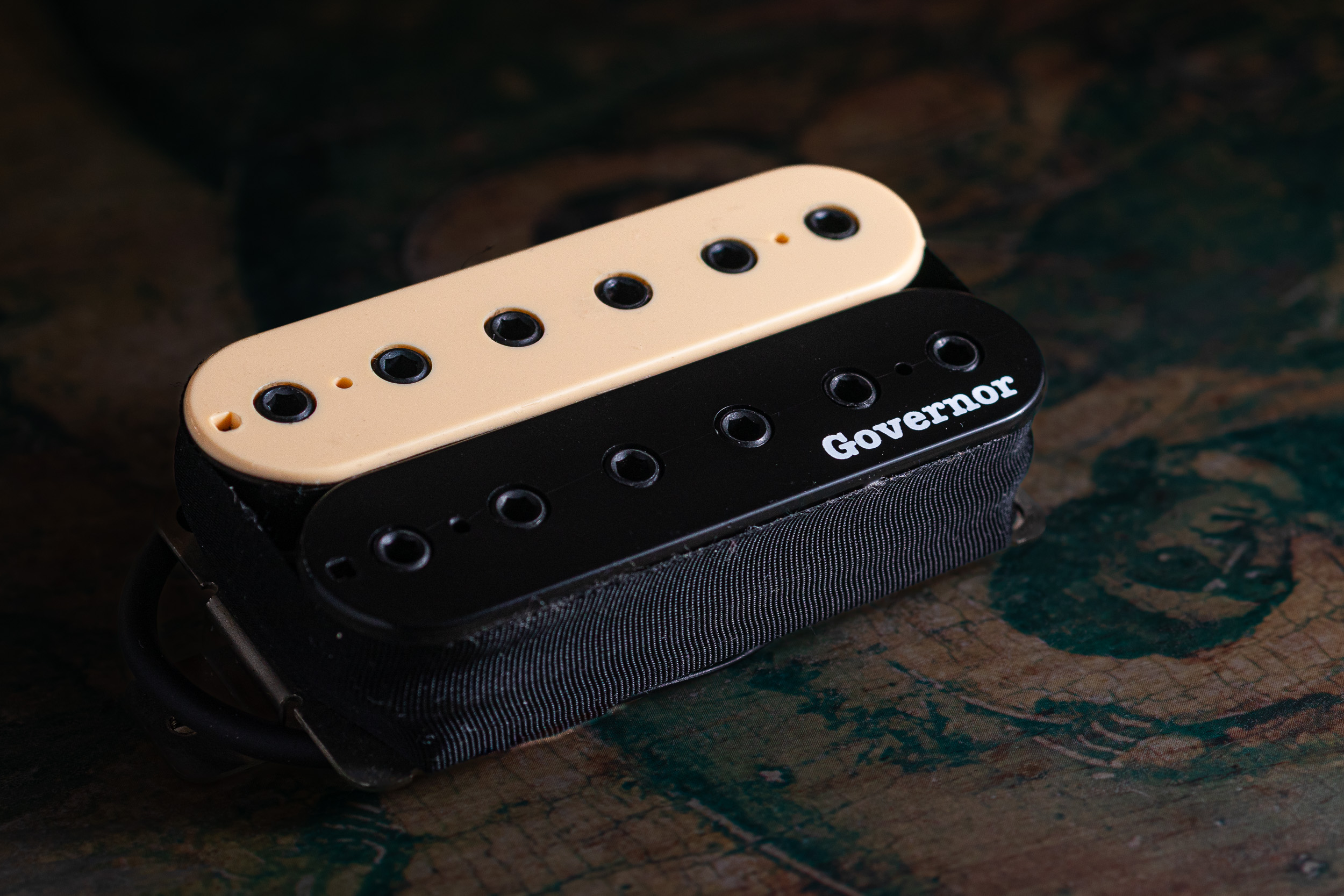 Guitar pickup detail on a textured surface