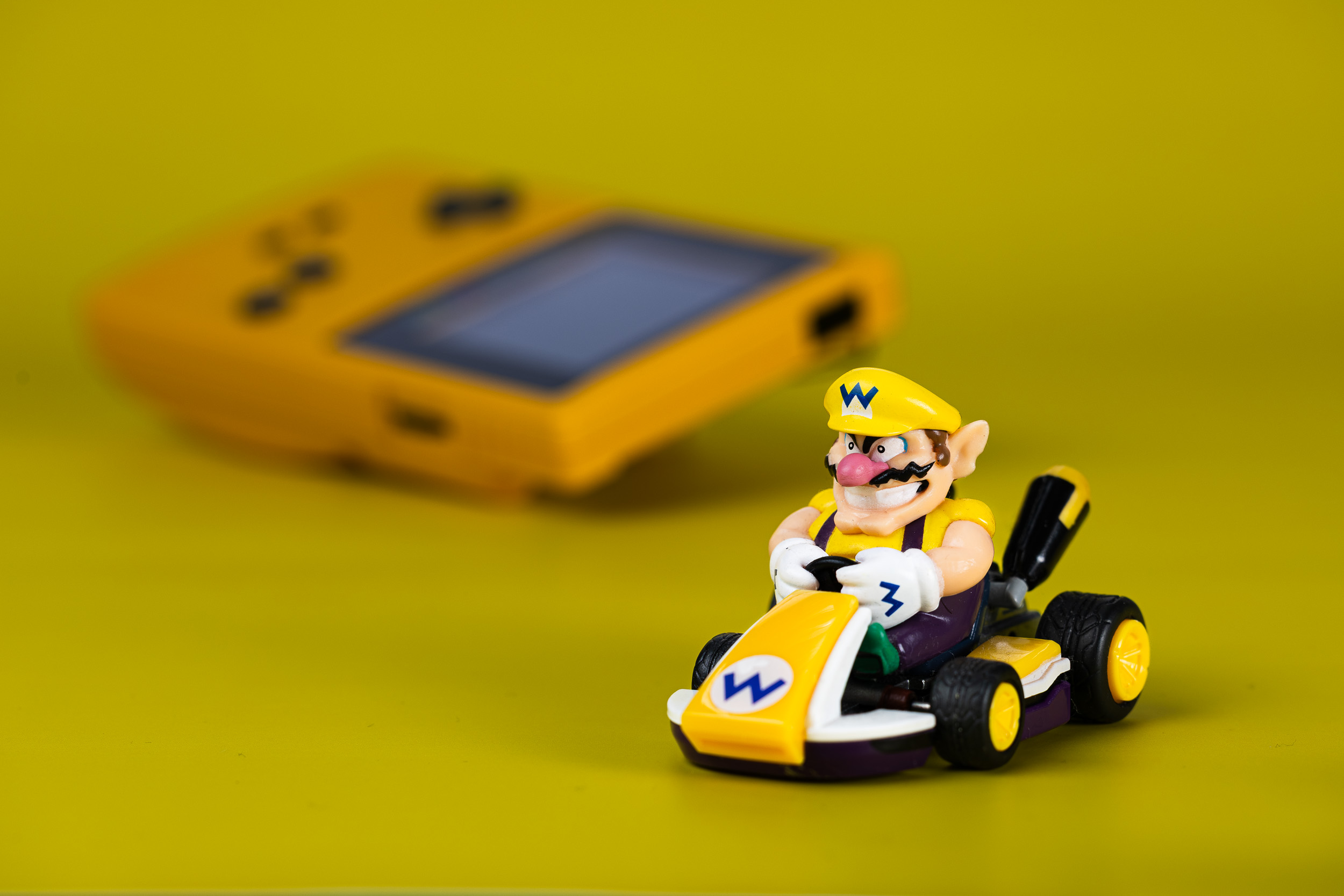 Small toy kart against a yellow background